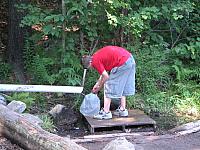 Alex collecting water at Bond Mountain Spring